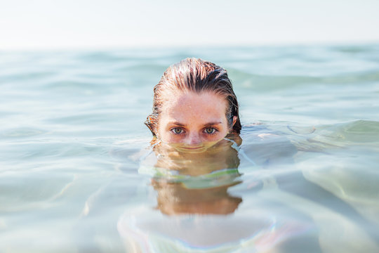 Portrait of a young woman standing underwater on the beach