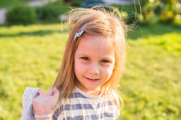 Portrait of happy child girl playing in summer in nature