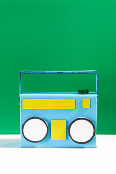 Diy retro ghetto blaster made by cardboard in front a green background