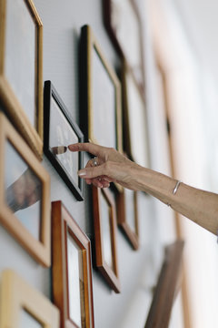Senior Woman Looking at Photos on wall