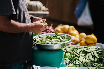 Close up of the farmers market vendor shelling fava beans