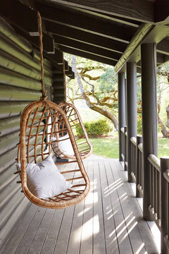 Swing chairs on porch of modern design log cabin