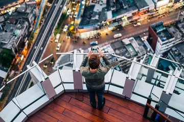 Capturing the moment - man taking a photo of a breathtaking city view