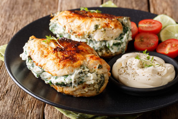 Baked Chicken fillet stuffed with cheese and spinach with sauce close-up. horizontal