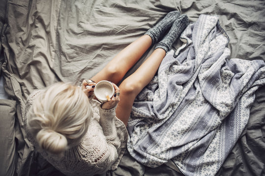Woman Drinking Hot Coffee in Bed in the Morning