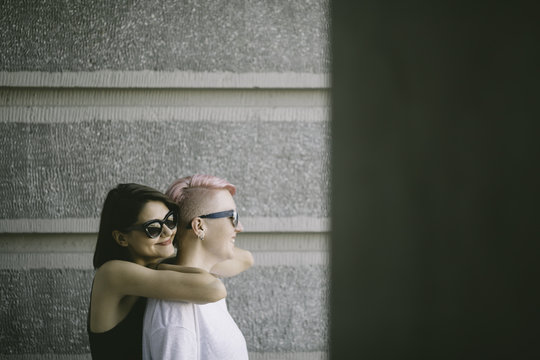 Lesbian couple wearing sunglasses and standing together