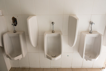 White porcelain urinals in public toilets.