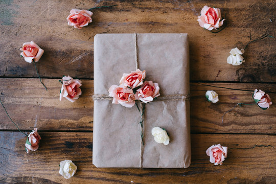 Gift wrapped in brown paper and decorated with flowers made from paper