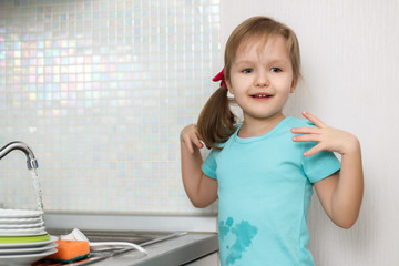 The little girl washes the dishes