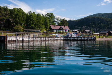 lake Baykal near green forest mountain and wooden house © kuzenkova