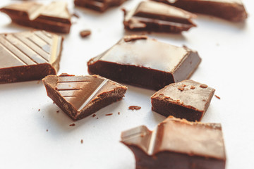 Chocolate pieces on white, selective focus, macro perspective