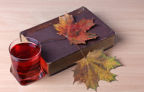 Glass of wine and book on wooden table