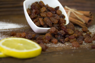 Raisins spilled from a bowl on the wooden table