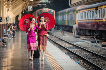 Obraz premium Piękna dziewczyna w tajskim stroju, azjatycka kobieta ubrana w tradycyjną tajską kulturę na stacji kolejowej w Bangkoku.