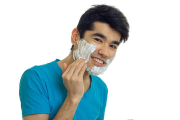 cheerful beautiful young guy putting a beard foam