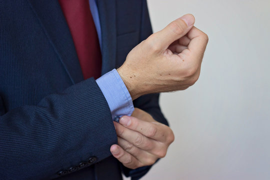 Business man fixing his cufflinks