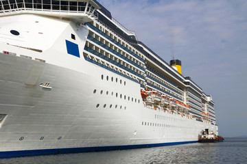 Cruise ship and tugboat - mooring the ship in port.