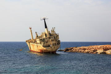 Seascape: boat EDRO III shipwrecked near the rocky shore at the sunset. Mediterranean, near Paphos. Cyprus