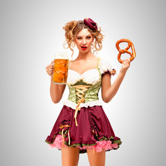 I know you what it / Beautiful Oktoberfest waitress wearing a traditional Bavarian dress dirndl holding a pretzel and beer mug, on grey background.