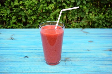 glass of strawberries, peach smoothie with straw on wooden table. Protein cocktail. Healthy drink. Fresh homemade smoothie. Healthy breakfast of smoothie,