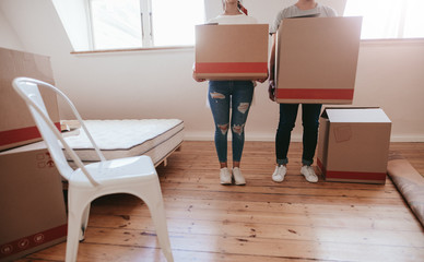 Couple with cardboard boxes moving to new house