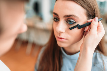 Makeup artist work with woman eyelashes