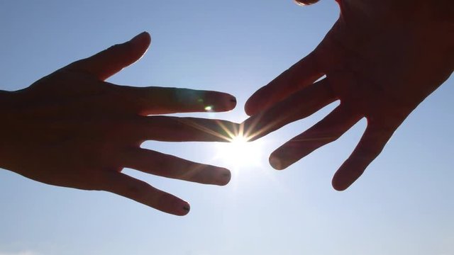 Female And Male Hands Touching Each Other With Finger Tips Against Sun In Blue Sky. HD, 1920x1080. 