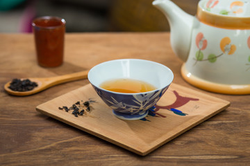 Tea cup and teapot on wooden table , close-up.