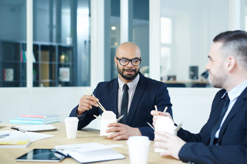 Small group of businessmen having lunch break in office