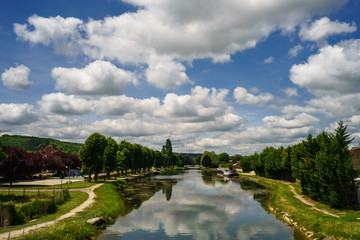 Fototapeta na wymiar F, Burgund, Schleuse bei Tonnerre am Canal de Bourgogne, leuchtender, strahlender Sommerhimmel mit weißen Wolken