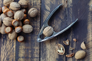Nuts and nutcracker on brown wooden background
