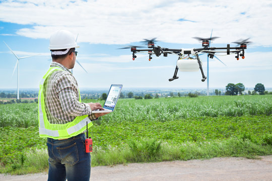 Technician farmer use wifi computer control agriculture drone on sugarcane field