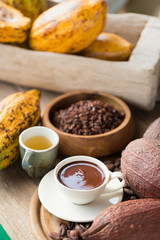 Fresh chocolate and.Liquid chocolate in white ceramic glass.on cocoa beans background.