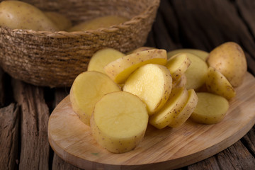Potatoes and potato sliced on wooden table. Selective focus