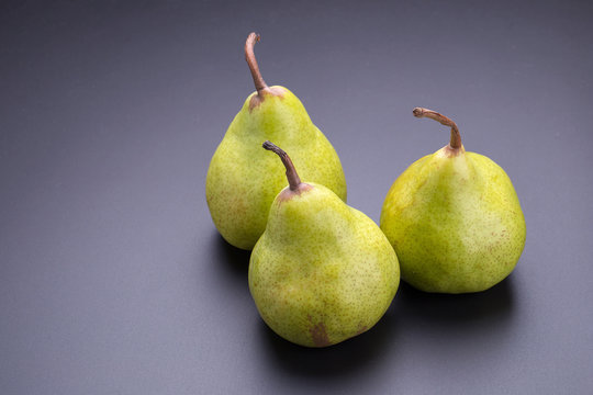 Close up of fresh green pears over black background