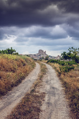 Beautiful scenery, country road on a background of a cloudy evening sky. Cappadocia, Turkey