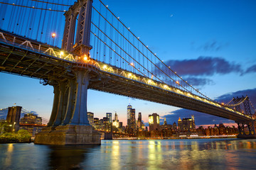 Manhattan bridge and New York City downtown skyline at dusk