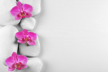 Fototapeta na wymiar Spa stones with orchid flowers on white background