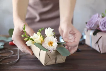 Photo sur Plexiglas Fleuriste Florist decorating box with flowers, closeup