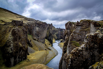 A man stands on a cliff in the Fjaðrárgljúfur canyon (Iceland)