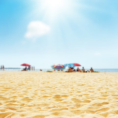 sand beach with peoples and sun in clouds