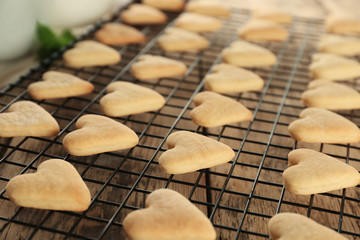Baking grid with heart shaped butter cookies on table