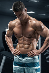 Fototapeta na wymiar Muscular man in gym, abs, working out. Strong male naked torso, shaped abdominal