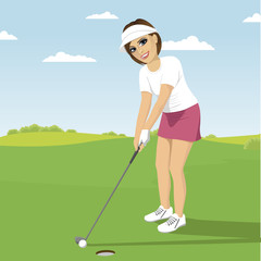 Young woman playing golf preparing to shot putting on green course