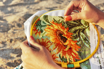 Woman making cross-stitch embroidery.