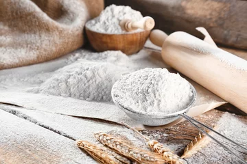  Sieve with flour on wooden background © Africa Studio