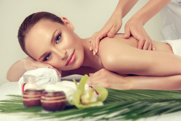 Plakat Massage and body care. Spa body massage treatment. Woman having massage in the spa salon for beautiful girl