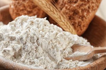 Heap of wheat flour and fresh bread, close up