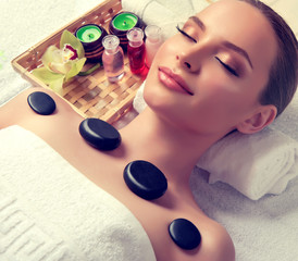 Obraz na płótnie Canvas Massage and body care. Spa body massage treatment. Woman having massage in the spa salon for beautiful girl . hot stone massage