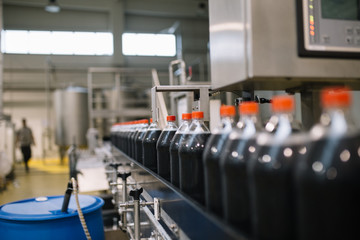Bottling factory - Coke bottling line for processing and bottling juice into bottles. Selective focus. 
